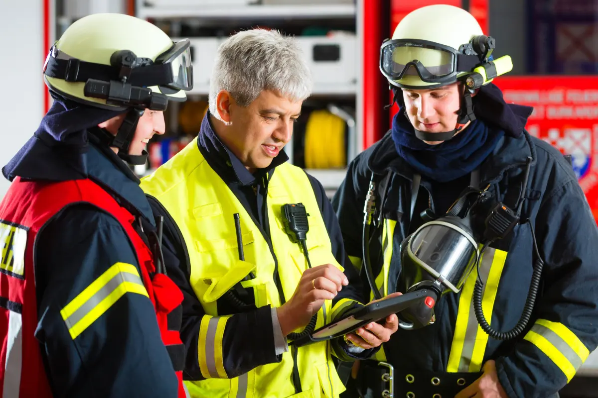 Firefighters reviewing information on a tablet.
