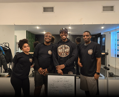 Four people posing in a gym setting.